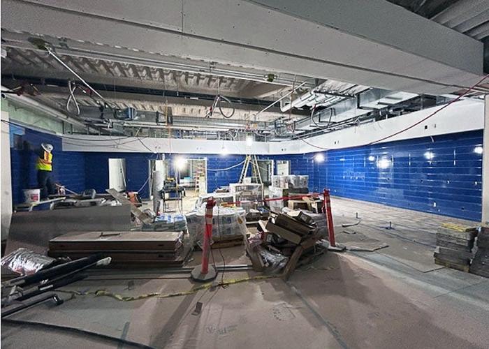 a large space under construction with blue tiles on the wall and construction materials in the room